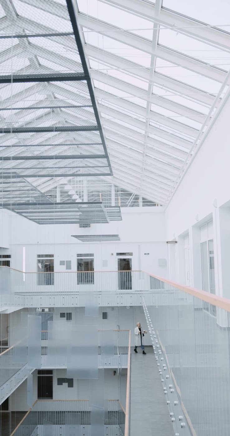 A bright office atrium with a colleague walking through